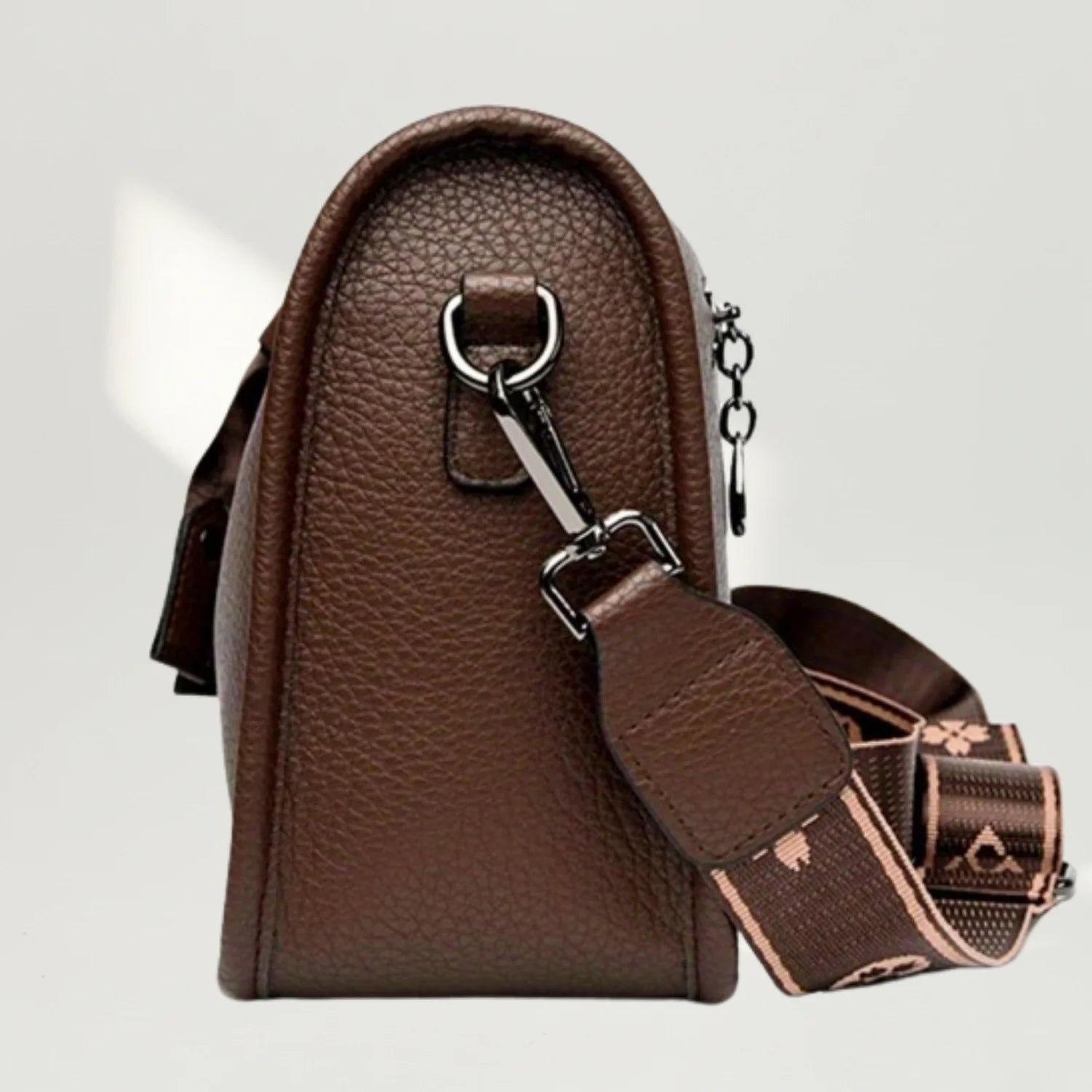 vista de lado da bolsa transversal em couro premium marrom com detalhes