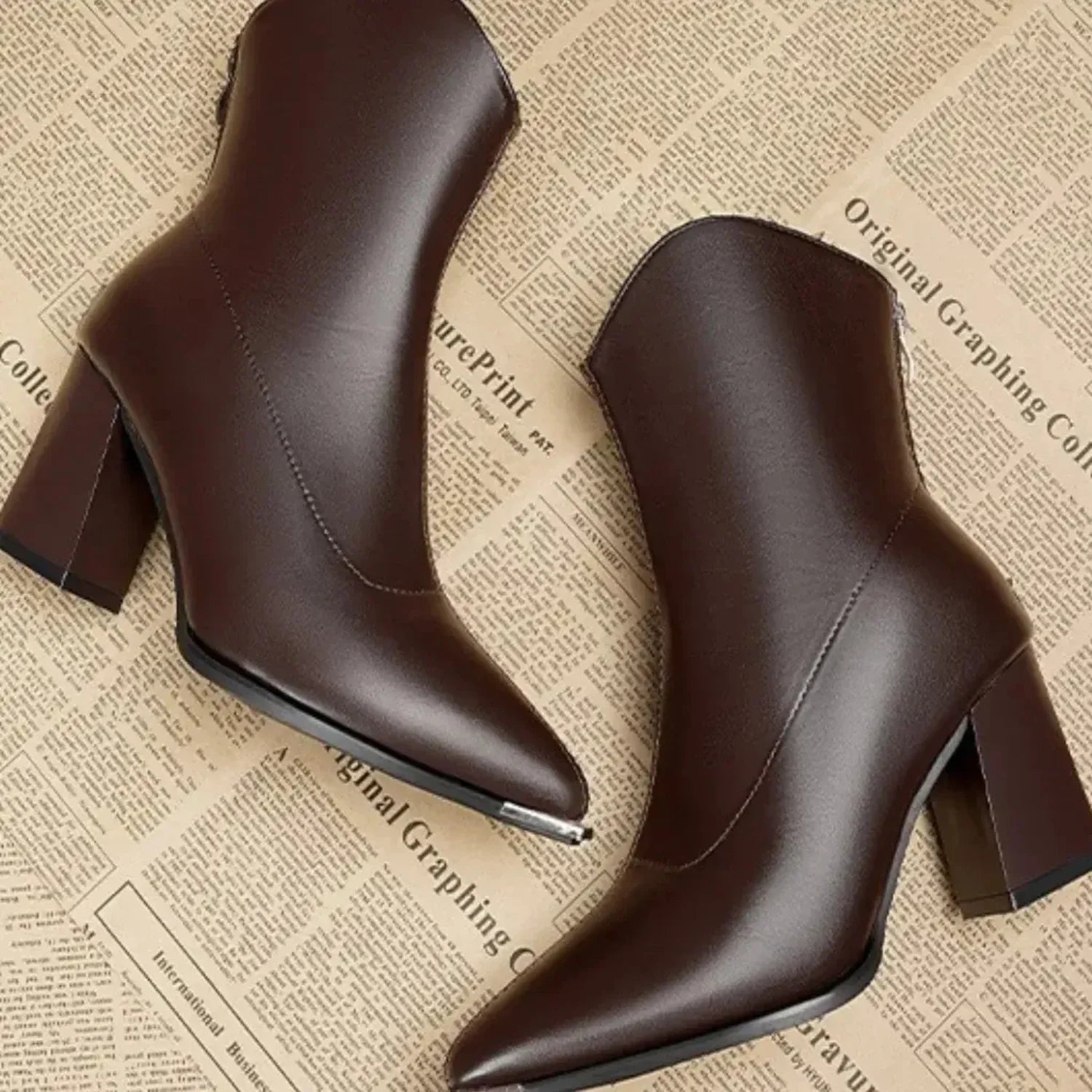 Bota feminina preta de cano curto com bico fino, salto bloco e acabamento sofisticado para looks elegantes.