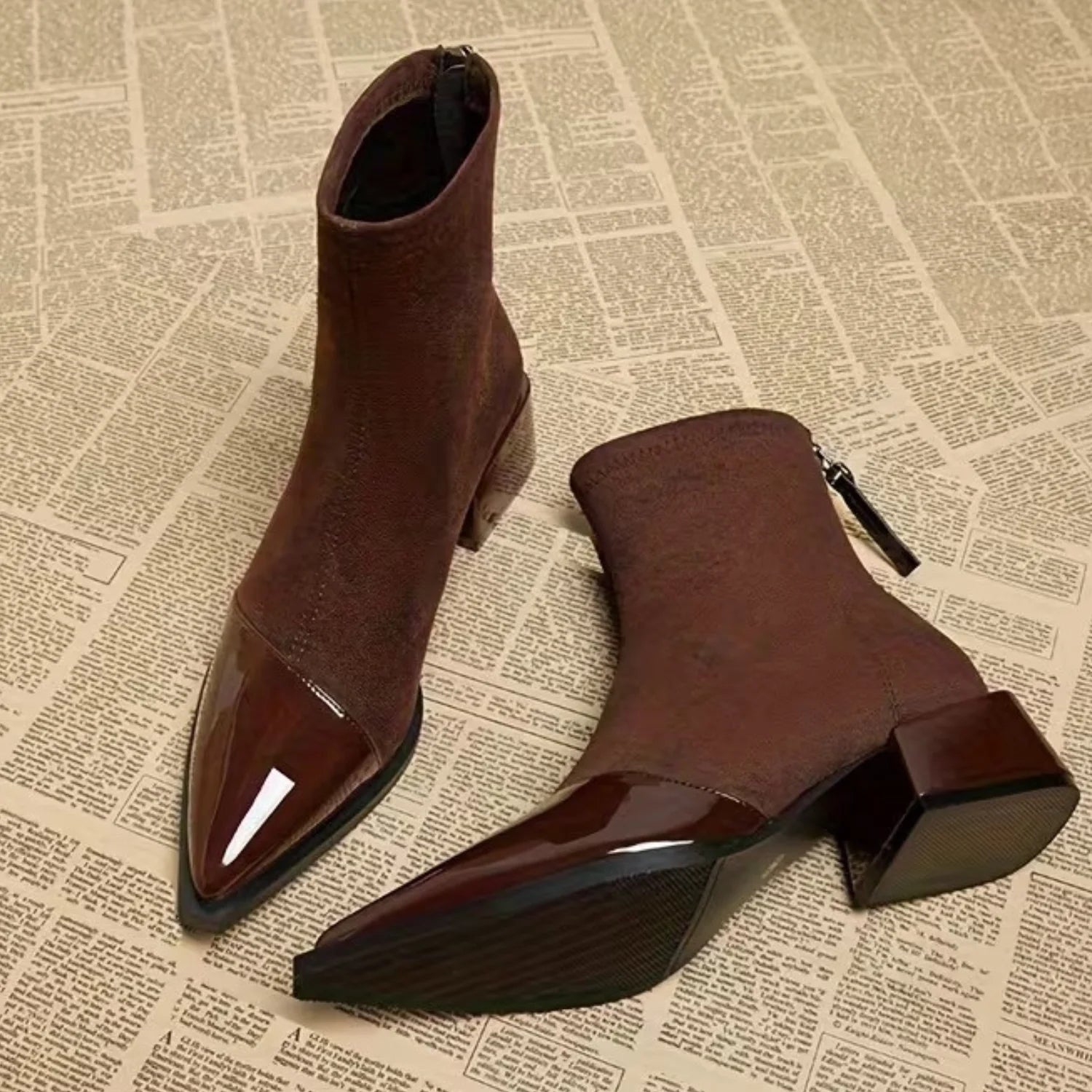 Par de botas femininas café com acabamento aveludado, bico fino brilhante e salto bloco confortável.