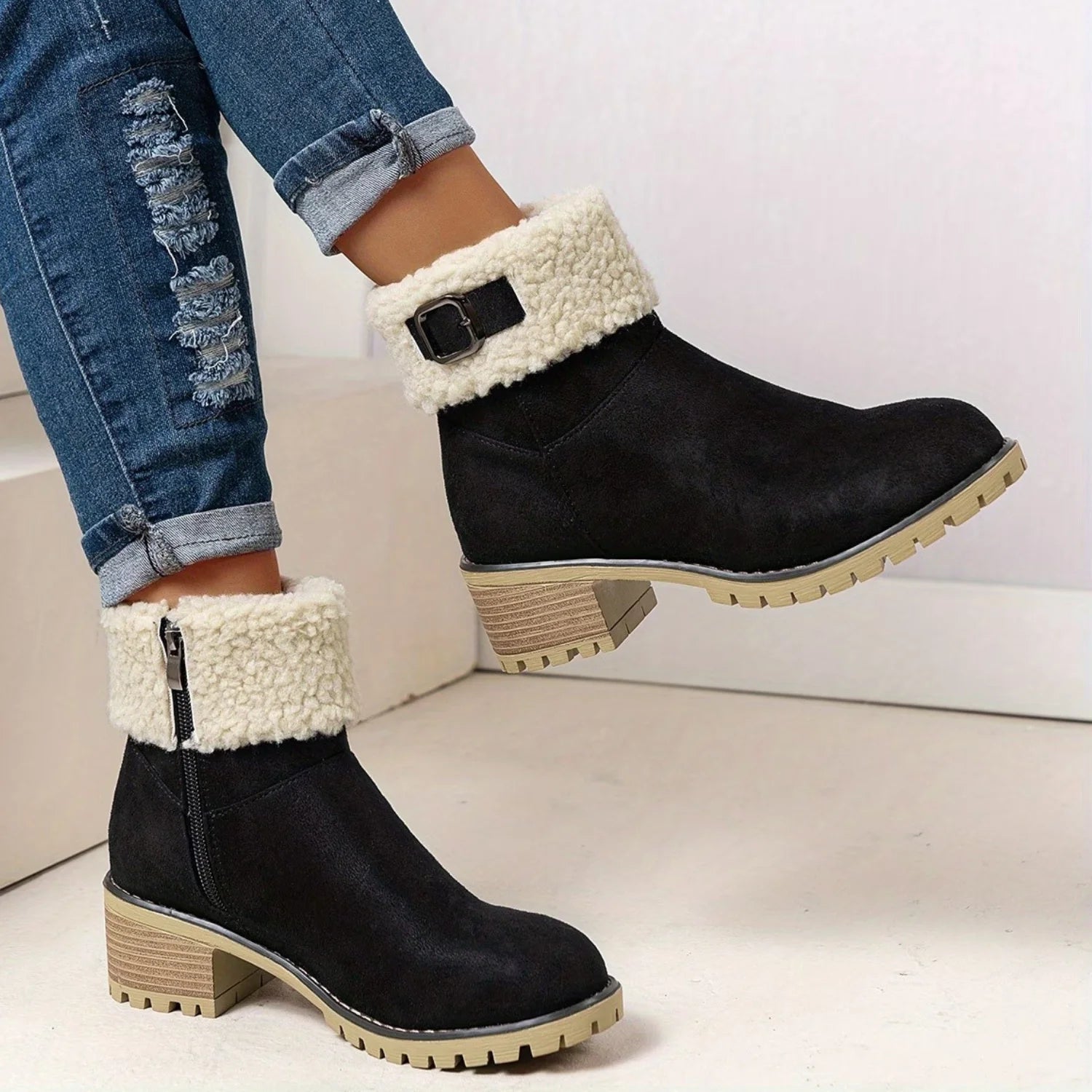 Vista lateral da bota feminina preta de cano curto com detalhe em pelo sintético, salto bloco e solado antiderrapante.
