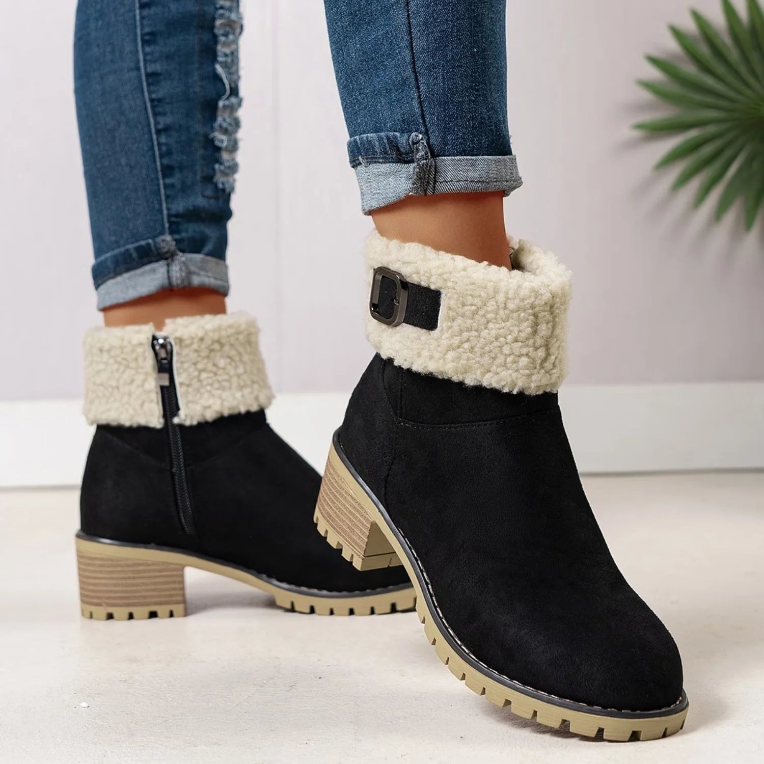 Bota feminina preta de cano curto com zíper lateral, forro peluciado, salto baixo e sola tratorada resistente.