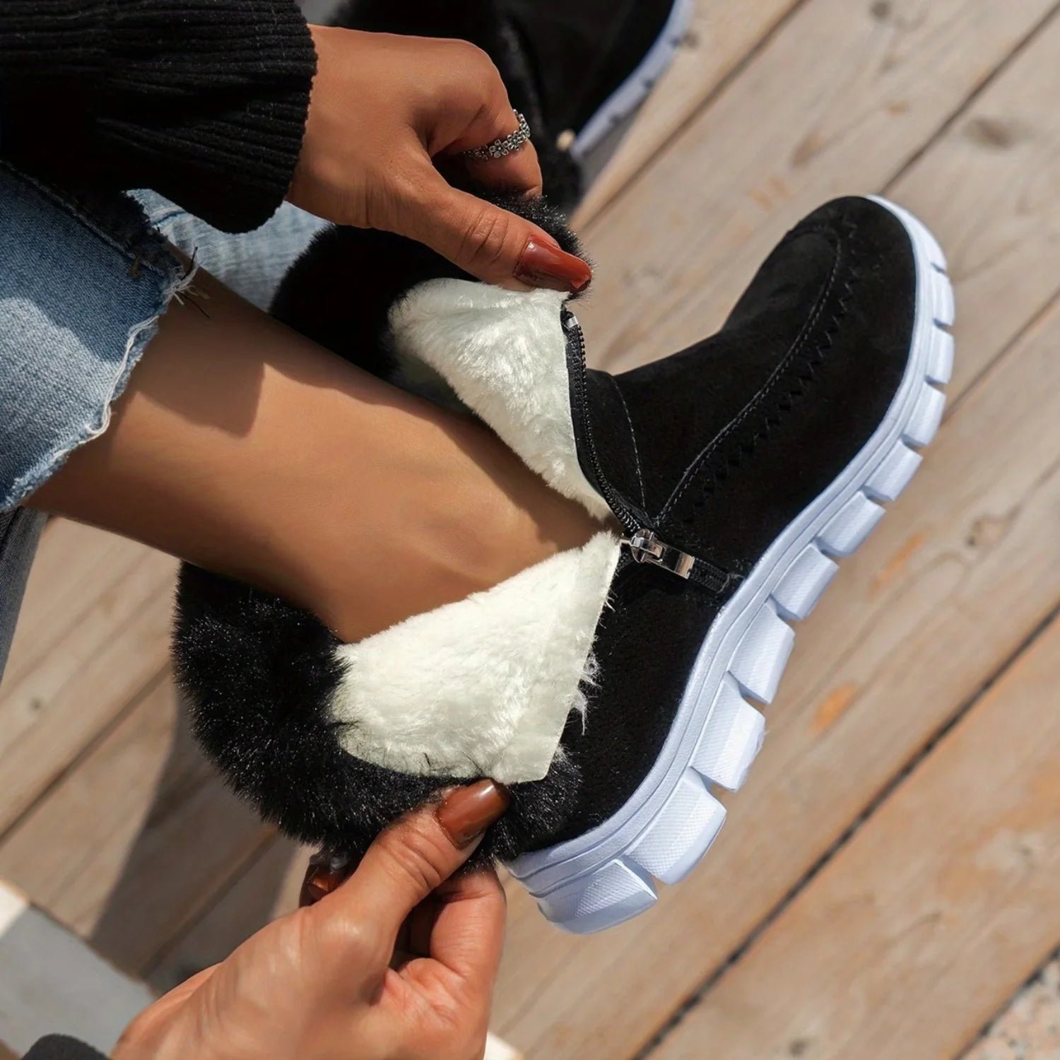 Detalhe da gola de pelo sintético da bota feminina preta