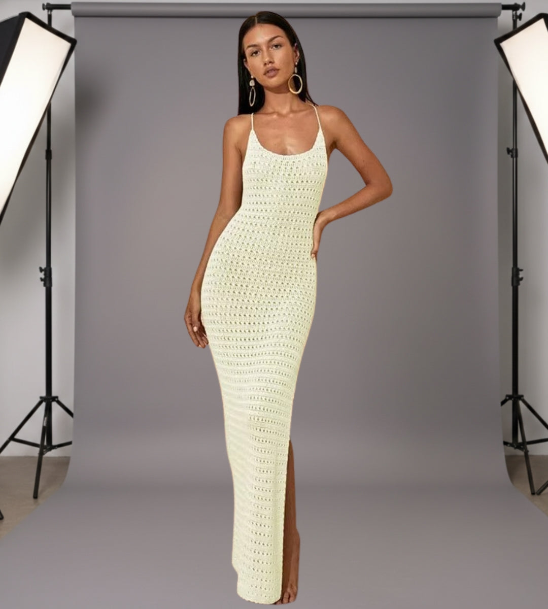 Mulher posando com vestido longo de tricô e óculos de sol em cenário de luxo à beira-mar.