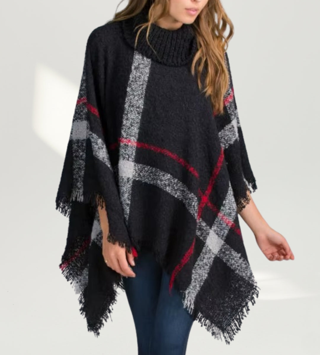 Modelo utilizando o Poncho Isolde Preto demonstrando o caimento fluido e o movimento das franjas.