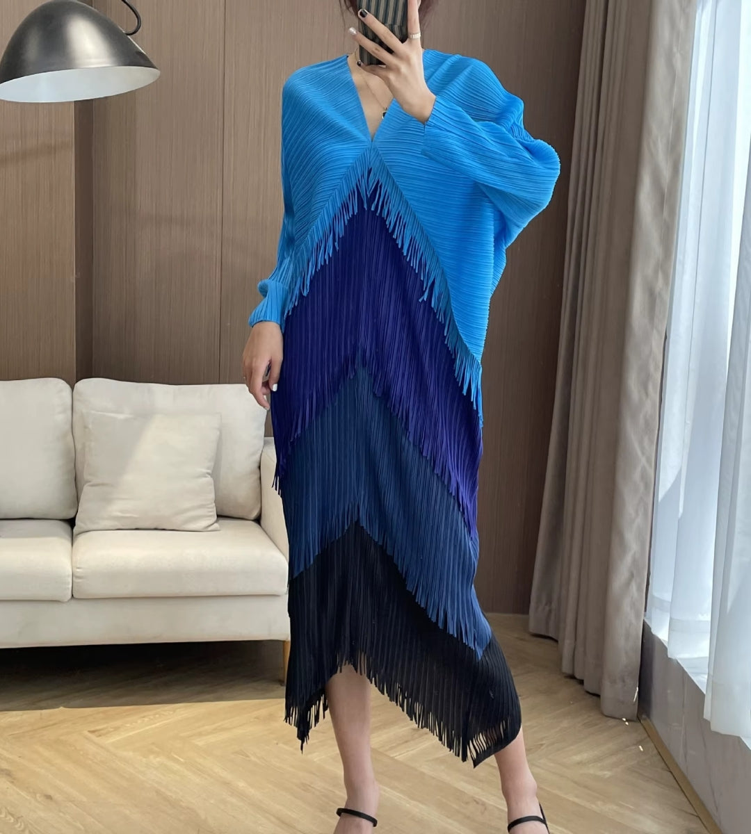 Modelo de frente usando o Vestido Midi Biarritz Royal Blue plissado com efeito degradê e mangas largas.