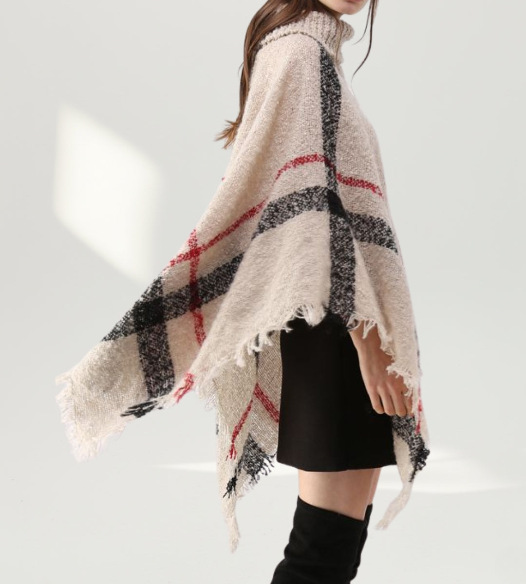 Visão traseira do poncho de tricô bege destacando o caimento fluido estilo capa nas costas