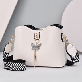 Vista lateral da bolsa feminina bucket bag preta destacando o encaixe da alça regulável