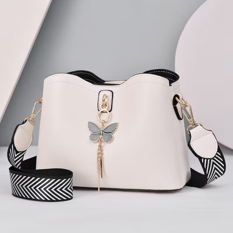 Vista lateral da bolsa feminina bucket bag preta destacando o encaixe da alça regulável