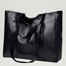 Vista frontal da Bolsa de Ombro Biarritz Preta com design tote clássico e alças reforçadas.