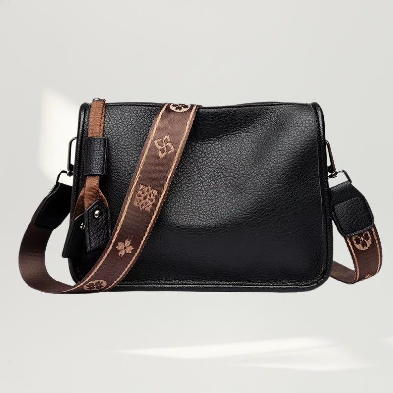 Vista frontal da Bolsa Charlotte Preta em couro legítimo com alça bordada exclusiva.