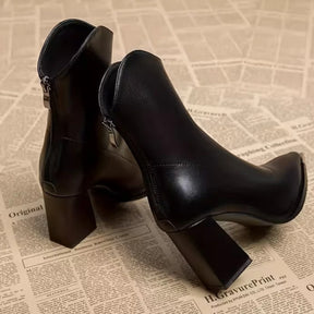 Par de botas femininas marrom cano curto com salto bloco e bico fino em acabamento premium.