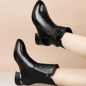 Par de botas femininas pretas em couro com zíper lateral
