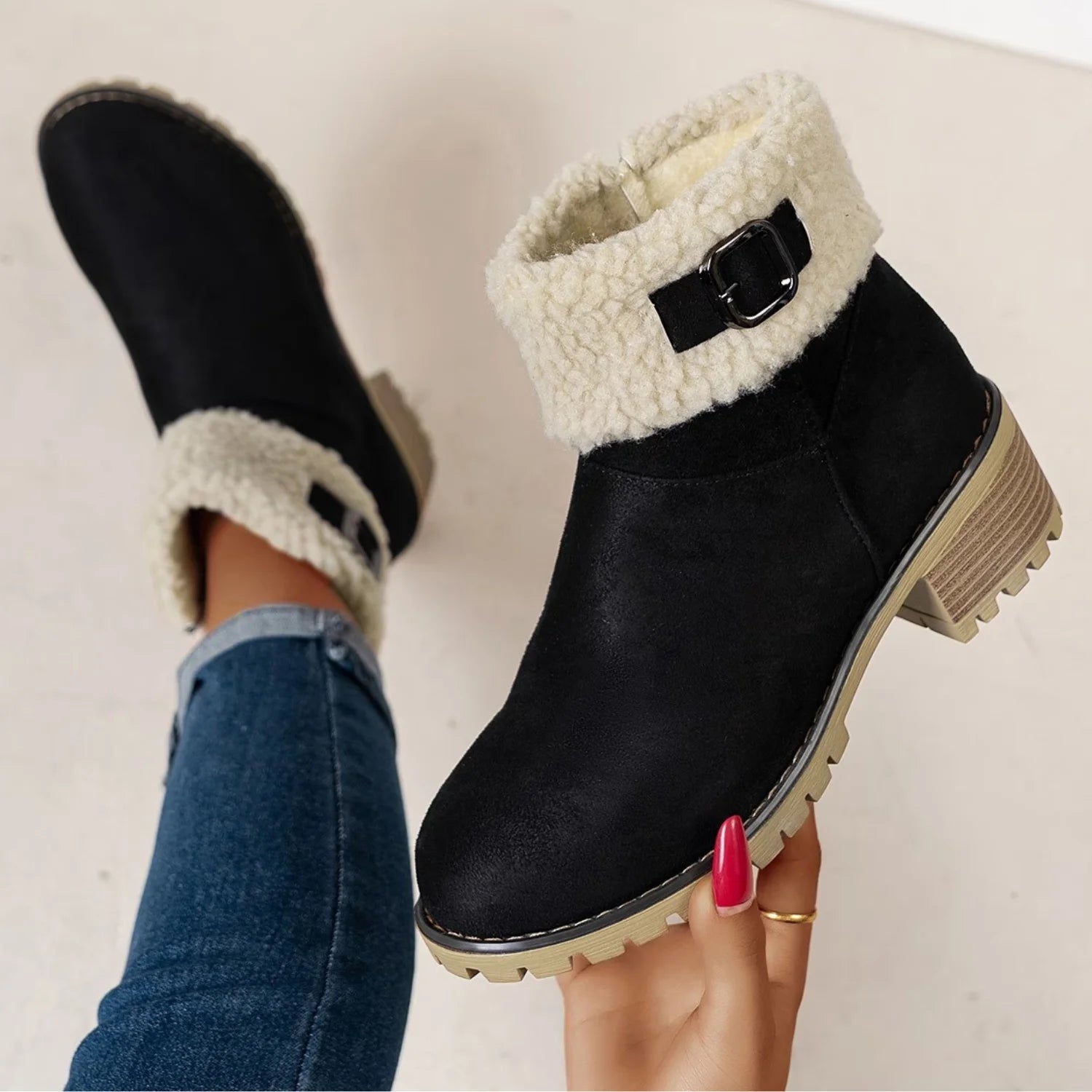 Bota feminina preta forrada com detalhe da fivela decorativa, acabamento em pelo sintético e salto baixo confortável.
