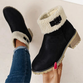 Bota feminina preta forrada com detalhe da fivela decorativa, acabamento em pelo sintético e salto baixo confortável.
