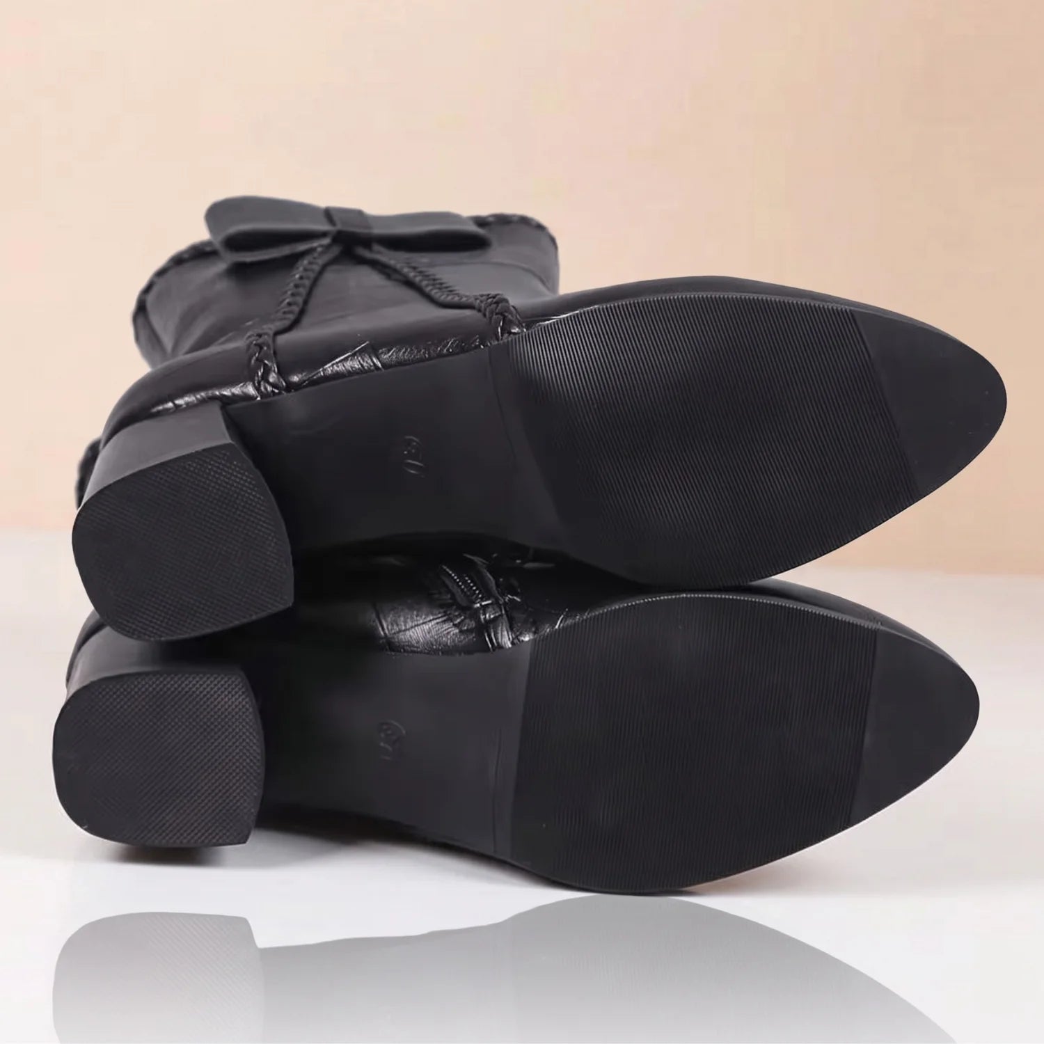 Bota feminina mostrando solado ortopédica preta com salto grosso de 5,5 cm
