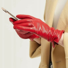 Detalhe em close do acabamento aveludado do couro vermelho e costura pespontada da luva