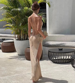 Modelo com vestido longo de tricô bege em cenário de resort litorâneo sofisticado