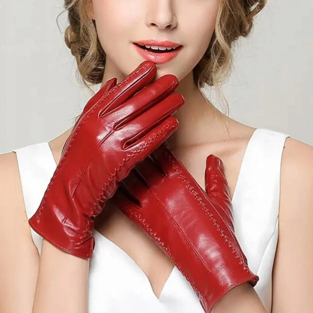 Mulher calçando par de luvas femininas em couro vermelho touch screen em look refinado de inverno