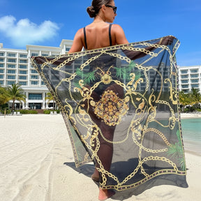 Saída de praia pareô estampada exibida nas costas em ambiente de resort à beira-mar.