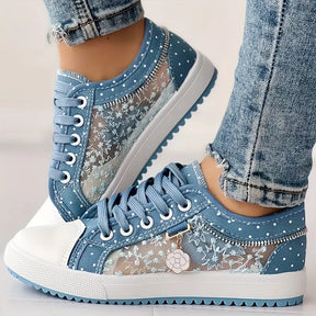 Mulher calçando tenis casual em renda floral bordada azul modelo Verona em vista frontal
