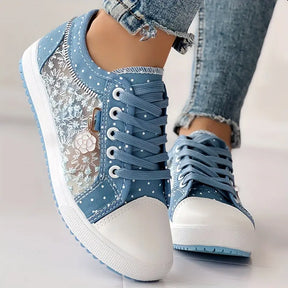 Tenis feminino em renda floral azul com solado de borracha branco isolado em fundo branco
