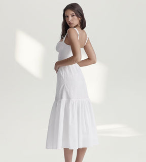 Detalhe lateral do vestido midi branco destacando os bordados em rechilieu e a modelagem ajustada na cintura.