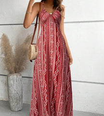 Mulher posando com o vestido longo vermelho Almería exibindo a padronagem ornamental rica em detalhes.