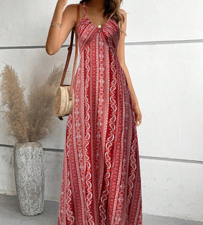 Mulher posando com o vestido longo vermelho Almería exibindo a padronagem ornamental rica em detalhes.