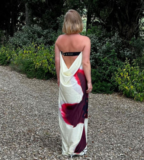 Mulher caminhando com vestido longo floral realçando o movimento leve do tecido tecnológico.