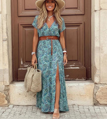 Modelo posando com o vestido longo azul de estampa paisley em cenário iluminado de verão.