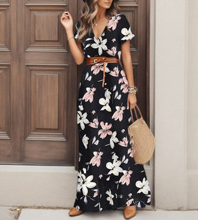 Mulher usando o clássico vestido preto longo Sevilla com padronagem paisley dourada.