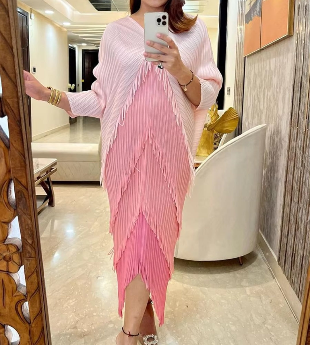 Modelo usando o vestido midi pink Biarritz com mangas morcego e movimento fluido na barra.