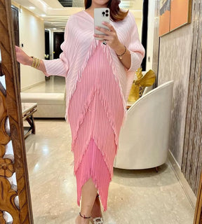 Modelo usando o vestido midi pink Biarritz com mangas morcego e movimento fluido na barra.