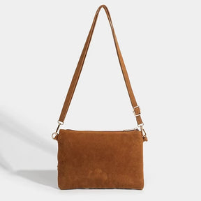 Visao da parte traseira da bolsa em suede marrom exibindo acabamento liso e costuras reforcadas